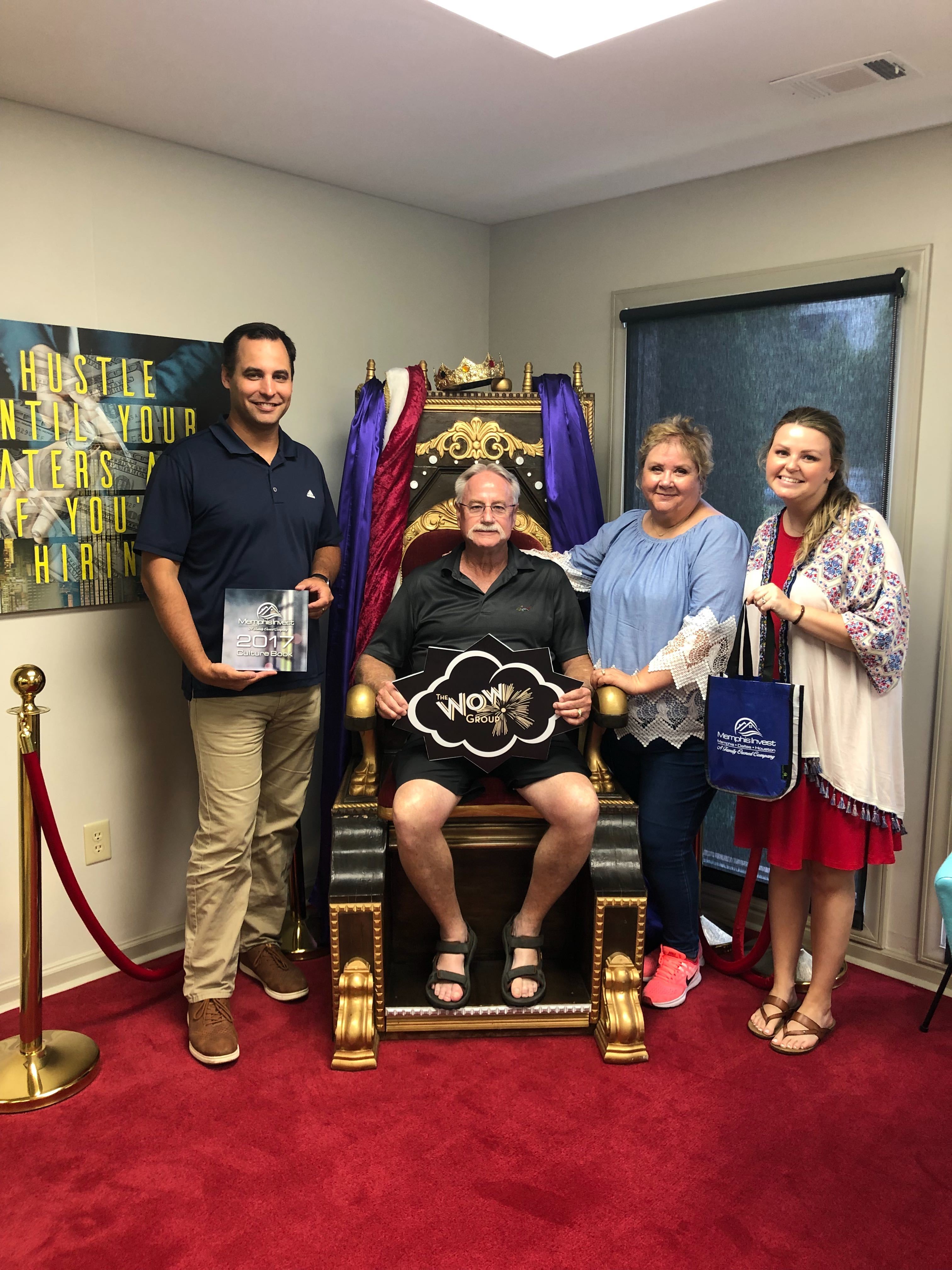 investor on rei throne holding up wow group sign