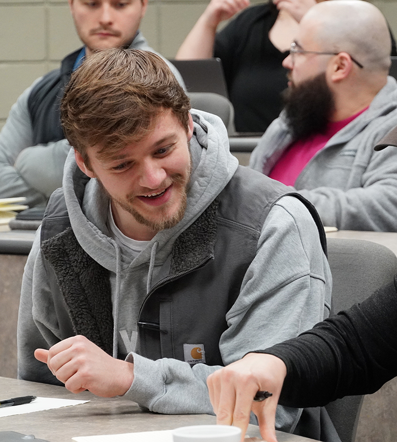 rei team member smiling looking down at paper in rotunda
